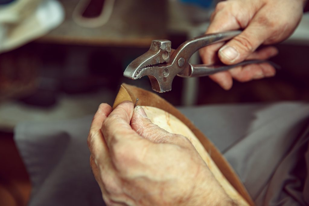 A man repairing a shoe soles of a replica yeezy